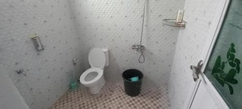 a bathroom with a toilet and a trash can at Vila Dinar Garden View in Lembang