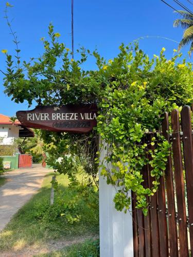 a sign that reads river breeze villa next to a fence at River Breeze Villa Bentota in Bentota