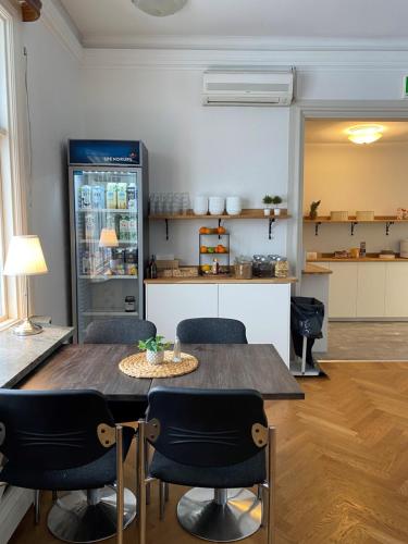 eine Küche mit einem Tisch und Stühlen sowie einem Kühlschrank in der Unterkunft Adels Hotel in Oskarshamn