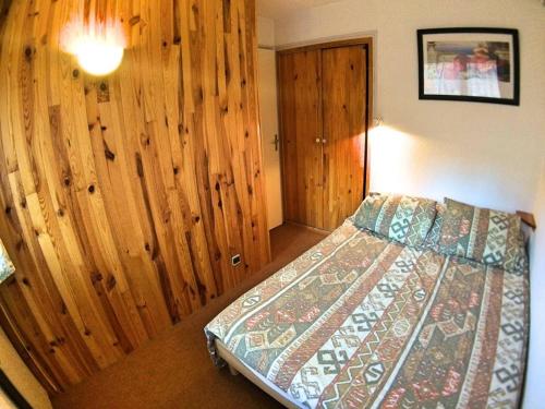 une chambre avec un lit et un mur en bois dans l'établissement Appartement 3 Chambres avec Coin Montagne, 8 Couchages, 400m des Pistes - Vars Les Claux - FR-1-330B-15, à Vars