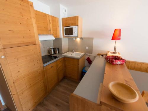 une petite cuisine avec une table et une lampe. dans l'établissement Appartement Duplex 4 Pièces avec Piscine - 6 Couchages, Proche Pistes - Vars Les Claux - FR-1-330B-31, à Vars