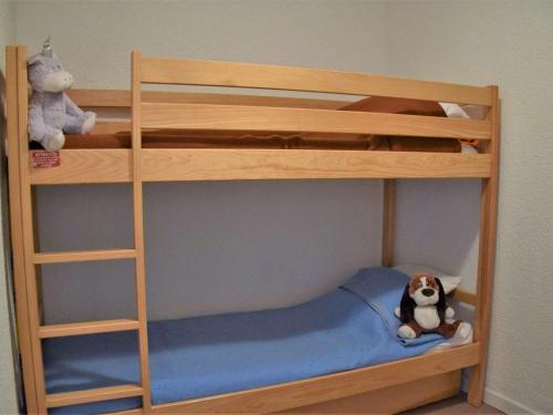 リスルにあるAppartement Risoul, 1 pièce, 4 personnes - FR-1-330-92の木製の二段ベッド(犬を乗せて座っている)