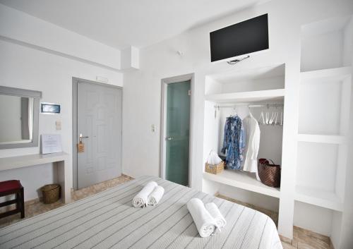 a white bedroom with a bed with towels on it at Anessis in Fira