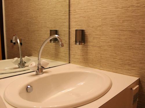 un lavabo de salle de bain avec un robinet et un miroir dans l'établissement Studio cosy à Vars avec balcon, proche pistes et commerces, parking inclus - FR-1-330B-38, à Vars