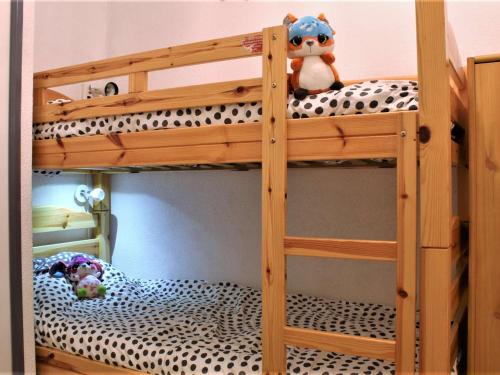 - un lit superposé en bois avec un animal rembourré assis au-dessus dans l'établissement Appartement studio cosy à Risoul - Idéalement situé, 4 couchages - FR-1-330-126, à Risoul