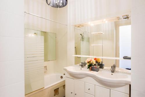 La salle de bains blanche est pourvue d'un lavabo et d'une baignoire. dans l'établissement LE SIRIUS AP4314 By Riviera Holiday Homes, à Nice