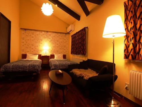 a living room with two beds and a couch at Villa Monrepos in Myoko