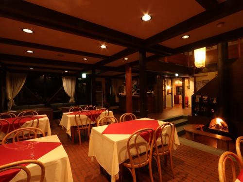 a restaurant with tables and chairs and a fireplace at Villa Monrepos in Myoko
