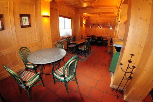 a dining room with tables and chairs and a kitchen at Hotel Dufour in Gressoney-la-Trinité
