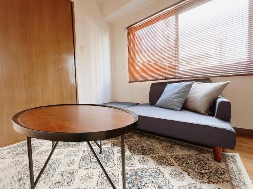 a living room with a couch and a table at PINE TREE HOTEL in Hiroshima