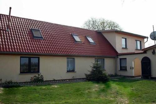 une grande maison blanche avec un toit rouge dans l'établissement Rügen Fewo 38, à Dreschvitz