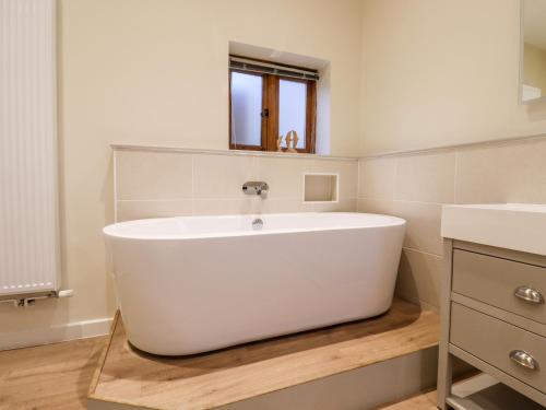 a bathroom with a white tub and a sink at Little Batts in Edenbridge