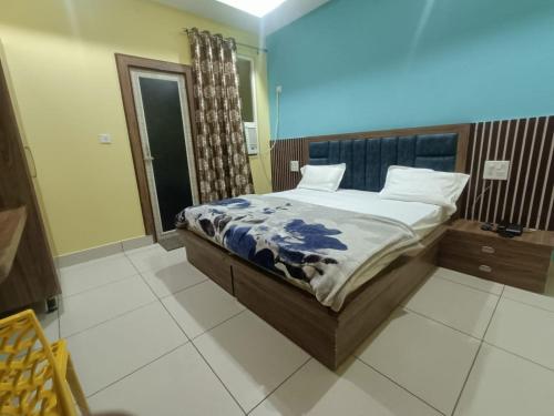 une chambre avec un lit avec une couette bleue et blanche dans l'établissement Om hotel, à Rohtak