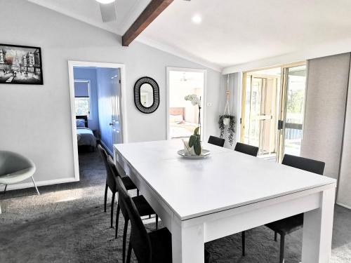 a white dining room with a white table and chairs at Rare Find! 5-Bedroom Home with Pool and Pool Table in Muswellbrook