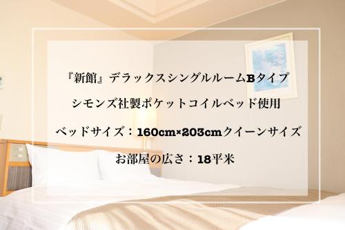 a bedroom with a wall with chinese writing on it at Imabari Urban Hotel in Imabari
