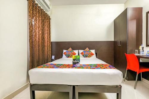 a bedroom with a bed and a table and a chair at FabHotel RMS Comforts - Nr Yeshwantpur Railway Station in Bengaluru