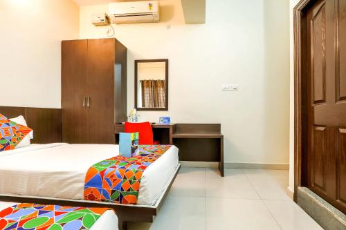 a hotel room with two beds and a desk at FabHotel RMS Comforts - Nr Yeshwantpur Railway Station in Bengaluru