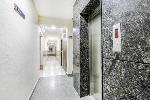 a hallway with a door with a tile wall at FabHotel RMS Comforts - Nr Yeshwantpur Railway Station in Bengaluru