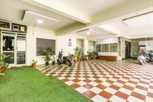 a room with a checkered floor and motorcycles in it at FabHotel RMS Comforts - Nr Yeshwantpur Railway Station in Bengaluru