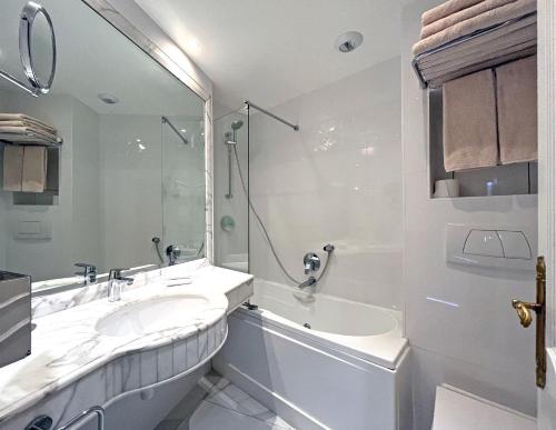 a white bathroom with a tub and a sink at Eiffel Trocadéro in Paris