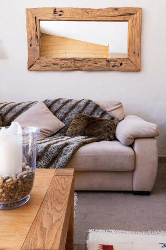 a living room with a couch and a mirror at Chalet Neva - luxury chalet with sauna by Avoriaz Chalets in Avoriaz
