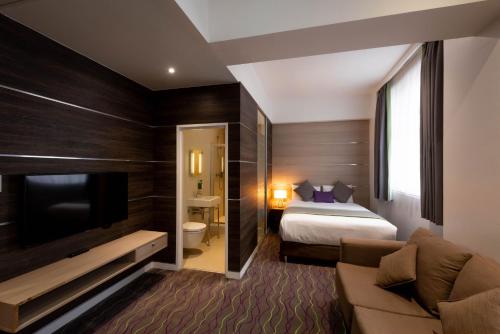 een hotelkamer met een bed en een televisie bij The Wesley Euston in Londen