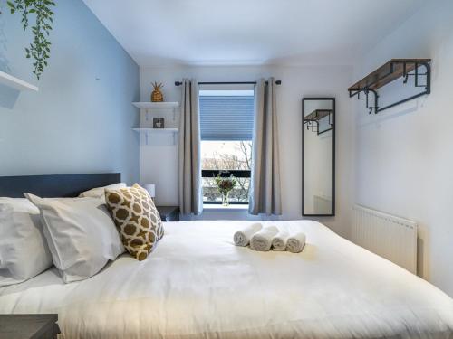sypialnia z dużym białym łóżkiem z ręcznikami w obiekcie Pass the Keys Stunning 2BR Apt w Balcony Views City Centre w mieście Belfast