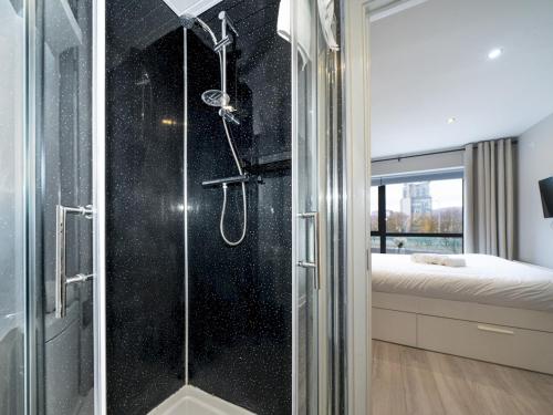 a shower with a glass door in a bedroom at Pass the Keys Stunning 2BR Apt w Balcony Views City Centre in Belfast