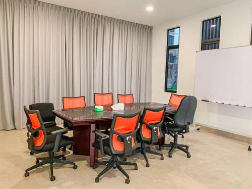 a conference room with a table and chairs and a whiteboard at D'pristine by Antlerzone in Johor Bahru