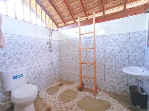 y baño con aseo y lavamanos. en Celemanik Villa, en Tabanan
