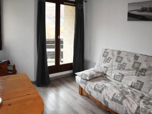 - un salon avec un canapé, une table et une fenêtre dans l'établissement Appartement Les Orres, 1 pièce, 4 personnes - FR-1-322-180, aux Orres