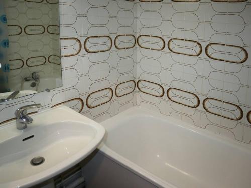 La salle de bains blanche est pourvue d'un lavabo et d'une baignoire. dans l'établissement Appartement Les Orres, 1 pièce, 4 personnes - FR-1-322-180, aux Orres