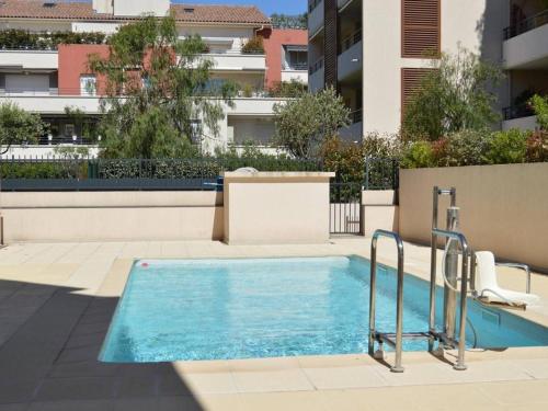 une piscine devant un immeuble dans l'établissement Spacieux 3 pièces avec terrasse, piscine et garage, à 2 pas de la plage – Saint Raphaël - FR-1-226A-274, à Saint-Raphaël