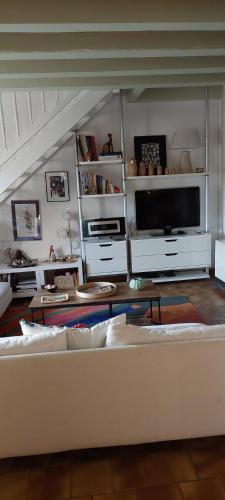 a living room with a white couch and a tv at Etxe Laminak in Sisteron