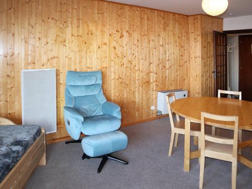 une chambre avec une chaise bleue et une table dans l'établissement Appartement 2 pièces 6 personnes - Centre station, Animaux admis, Parking - FR-1-322-152, aux Orres