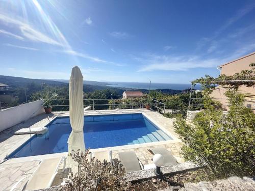 a swimming pool with a umbrella and a view at Villa Corfou in Corfu Town