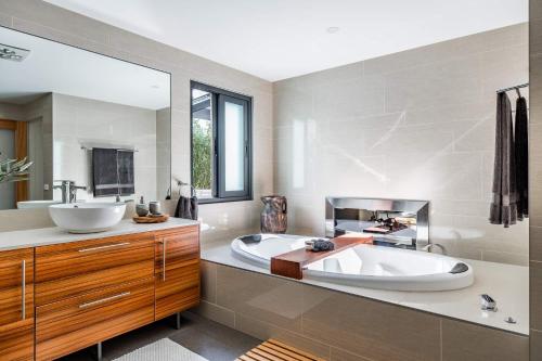 baño con bañera grande y lavamanos en Earimil Villas - Waterfront, en Mount Eliza