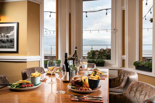 a dining room table with food and wine glasses at The Beaches Hotel and Spa in Prestatyn