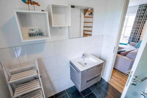 a bathroom with a sink and a mirror at Ferienwohnung 11 "Gut Tossens" in Tossenserdeich