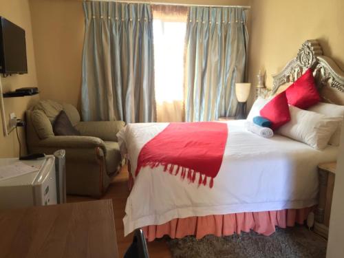 1 dormitorio con 1 cama con manta roja y blanca en Radies Bed and Breakfast, en Cofimvaba