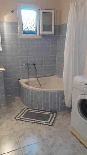 łazienka z wanną i pralką w obiekcie Gorjelina `s House w mieście Wolos