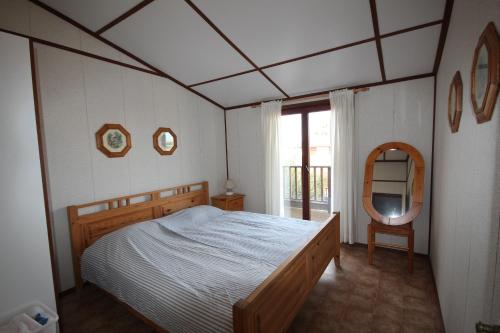 une chambre avec un lit et un miroir dans l'établissement Belle Maison climatisée 4 pièces 7 couchages- residence Portes du soleil , wifi, piscines payantes, LRPDSE7 PORTIRAGNES PLAGE, à Portiragnes