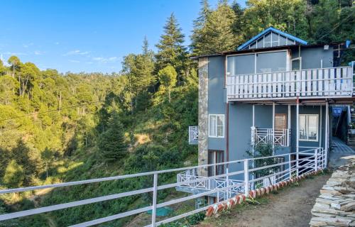 una casa en la ladera de una montaña en The Frostwood Resort, en Rānīkhet
