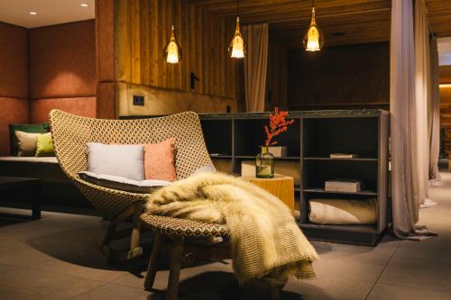 a room with a chair with a blanket on it at Das Traunsee - Das Hotel zum See 4 Stern Superior in Traunkirchen