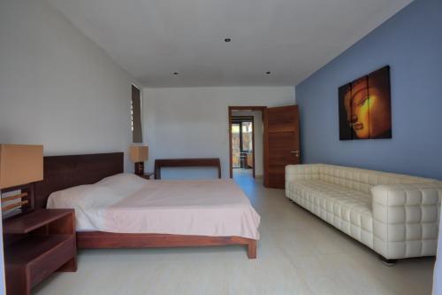a bedroom with a bed and a couch at Balinea Villas in Pereybere