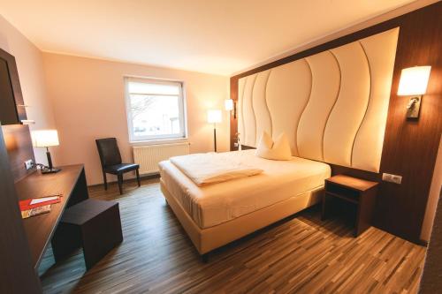a hotel room with a bed and a window at PLAZA Hotel Bruchsal in Bruchsal