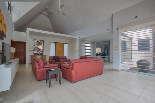 a living room with two red couches and a table at Balinea Villas in Pereybere