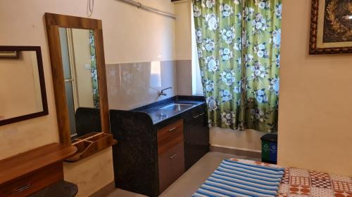 a bathroom with a sink and a mirror at Godwill Kimo Guest house Seraulim in Madgaon
