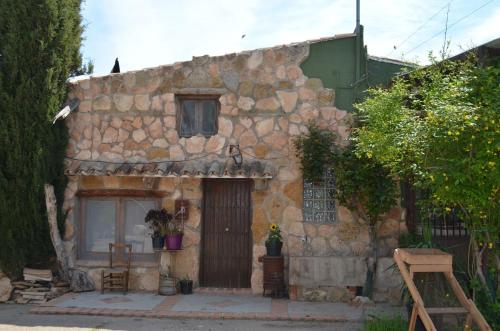 ein altes Steinhaus mit einer Tür und einem Fenster in der Unterkunft Granja El Regajo in Valencia