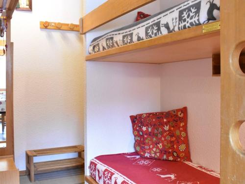 Les AlluesにあるStudio cosy 4 pers, centre Méribel, pistes à 50m, proche commerces et restos - FR-1-180-312の小さな部屋にある赤い枕が置かれた二段ベッド